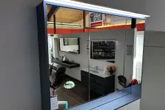 Geschlossener dreitüriger CUBE-Spiegelschrank von Koje 6 mit eingeschalteter LED-Leuchte