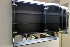 Geöffneter CUBE-Spiegelschrank von Koje 6 mit Glasböden und anthrazitfarbenem Innenraum